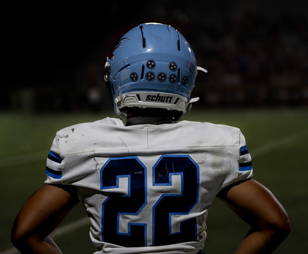 Player seen from behind under stadium lights