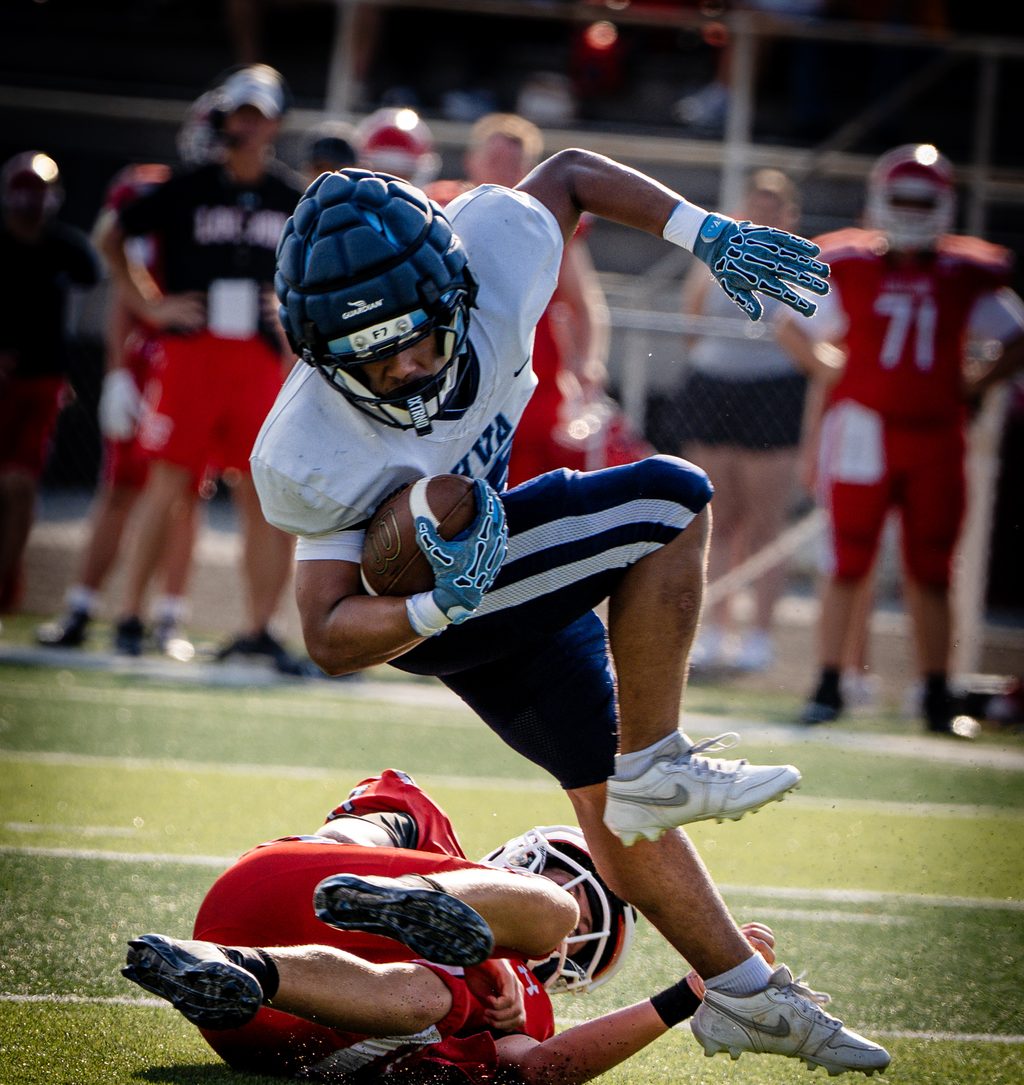 Ball carrier leaping over a falling defender