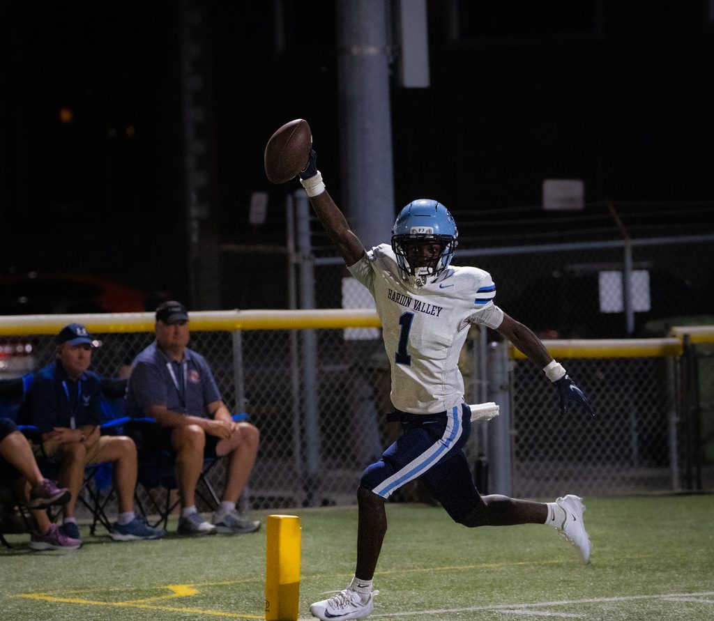 Receiver reaching for a pass under floodlights