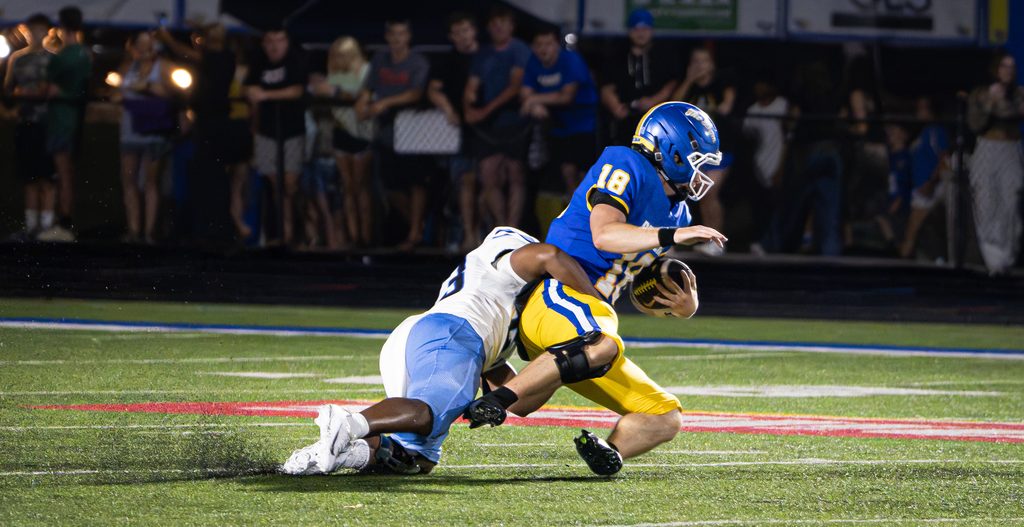 Defender bringing down a ball carrier in the open field
