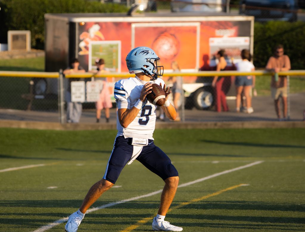 Quarterback releasing a throw in evening light