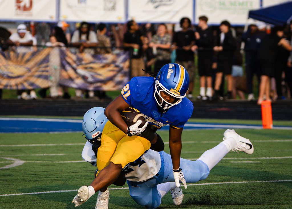 Ball carrier wrapped up and taken down near the sideline