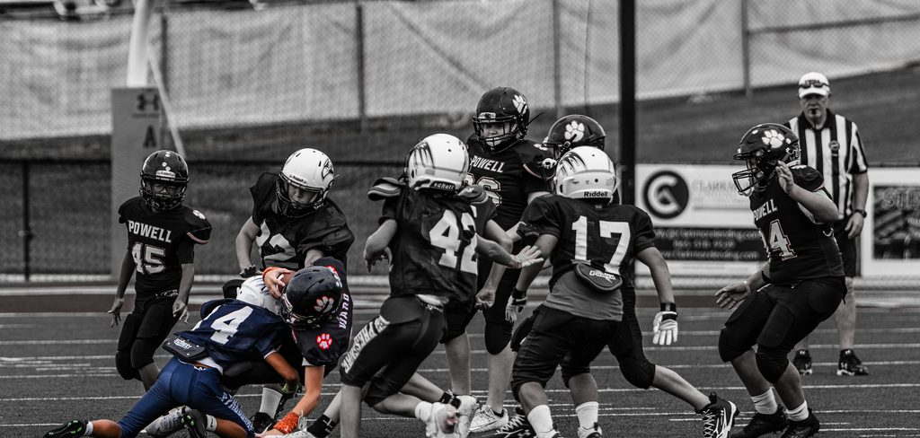 Players converging on the ball carrier, in black and white