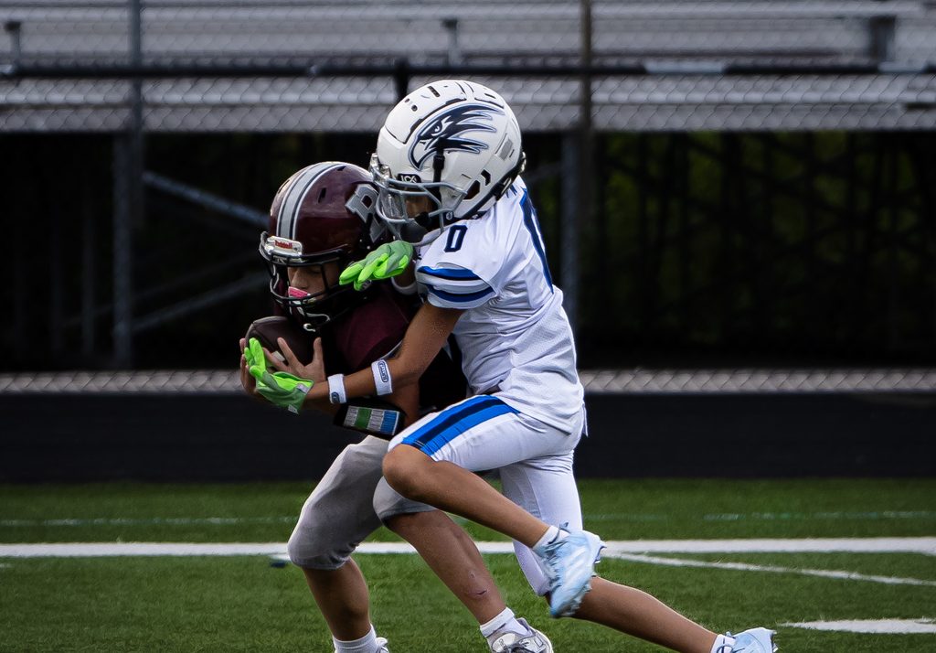 Ball carrier fending off a tackle