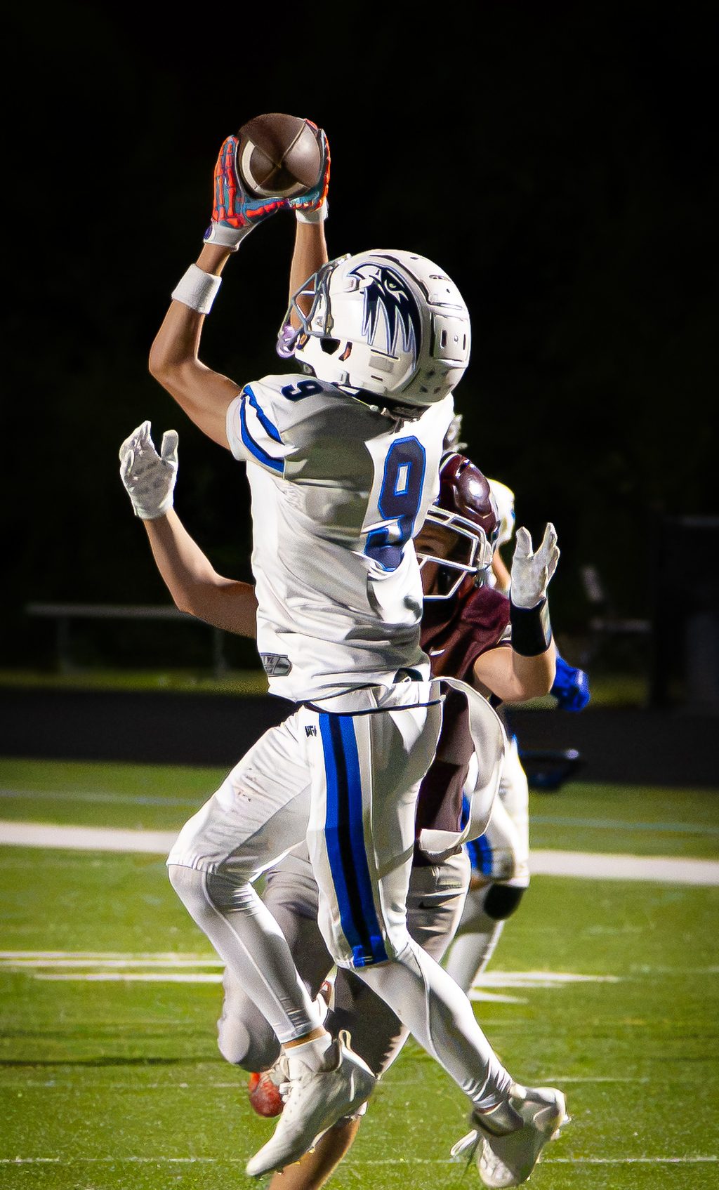 Player leaping for a catch under the lights