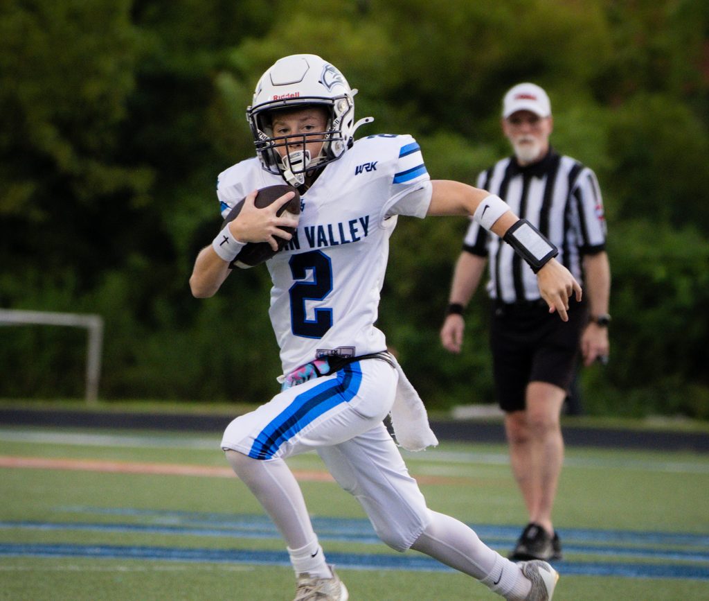 Ball carrier running upfield past the official